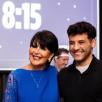 A grad smiles posing next to President Mantella